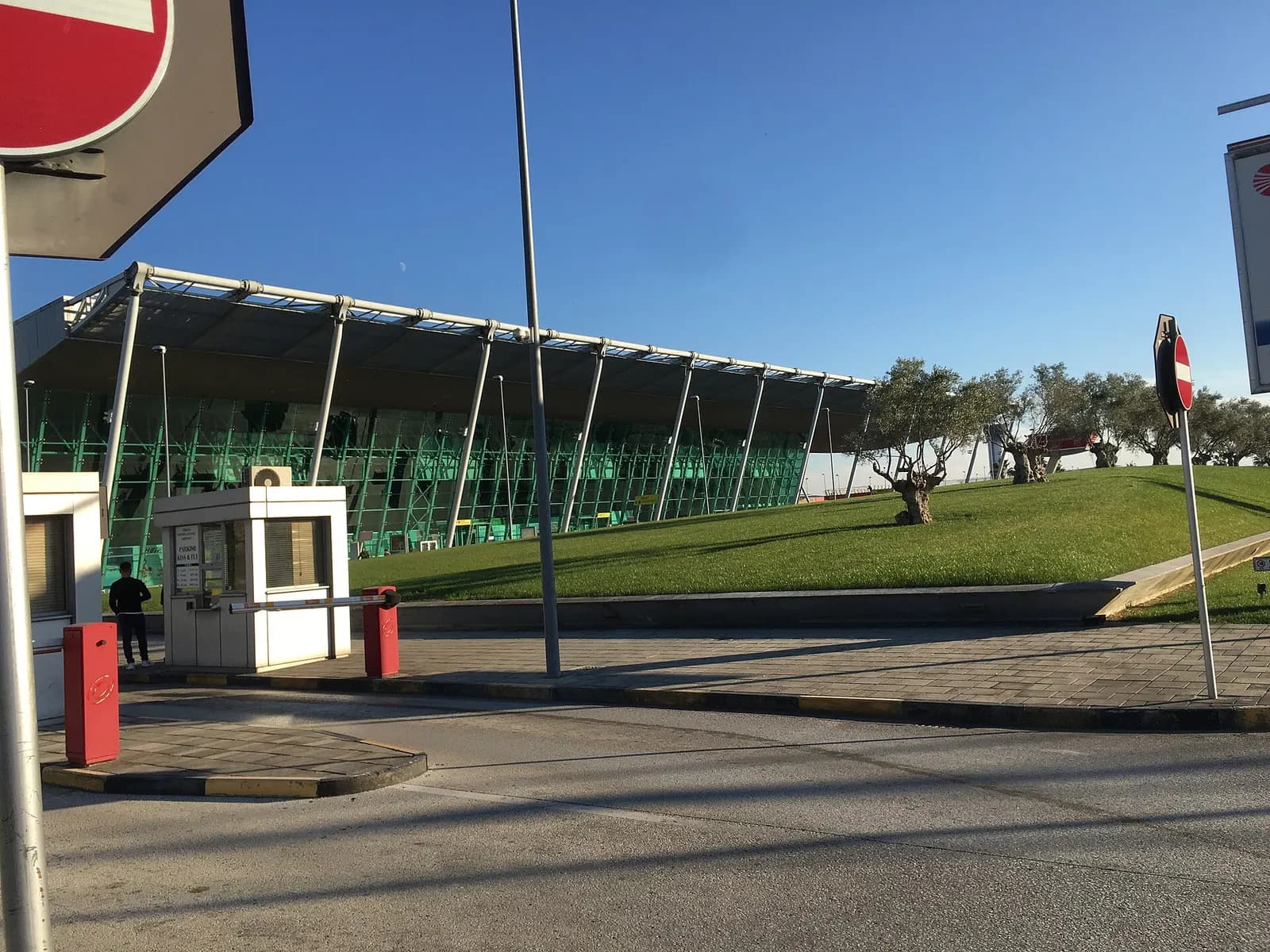 Tirana International Airport terminal seen from the parking entrance with Bashkia Tirana parking booth