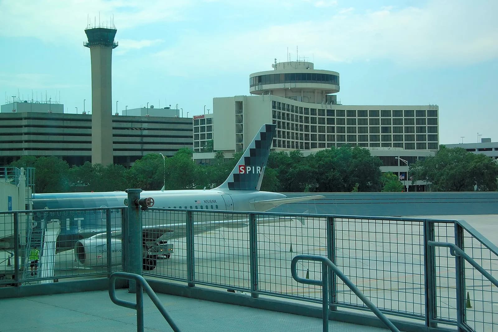 Travelers waiting at gates inside Concourse C at Tampa International Airport with aircraft visible through tall windows.