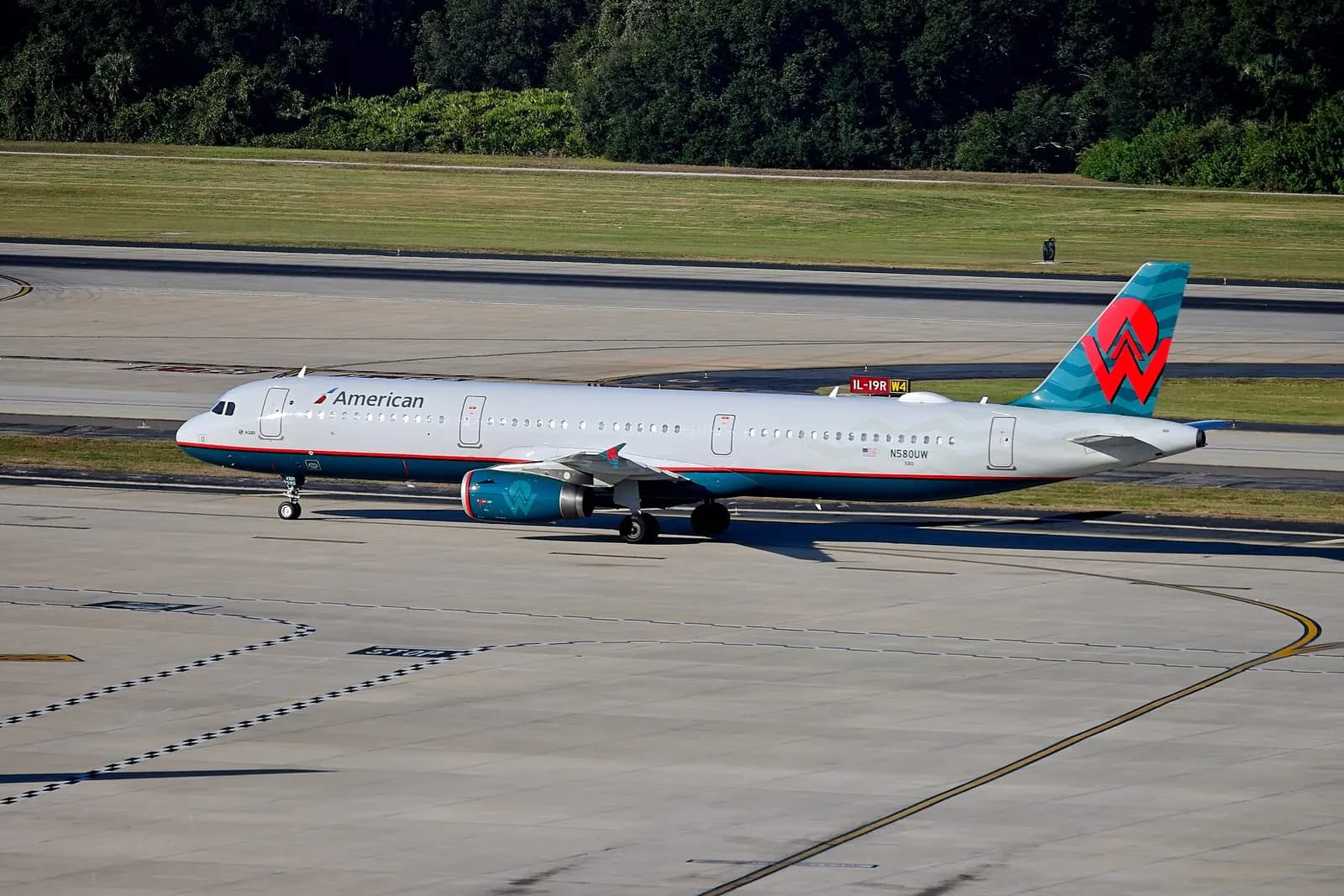 American Airlines N580UW, an Airbus A321, taxiing to its gate at Tampa International Airport after arriving from Charlotte (Flight AA2898). The aircraft sports a retro livery of America West. America West merged into US Airways in 2007, which later merged into American in 2015. (Note: Camera EXIF ti