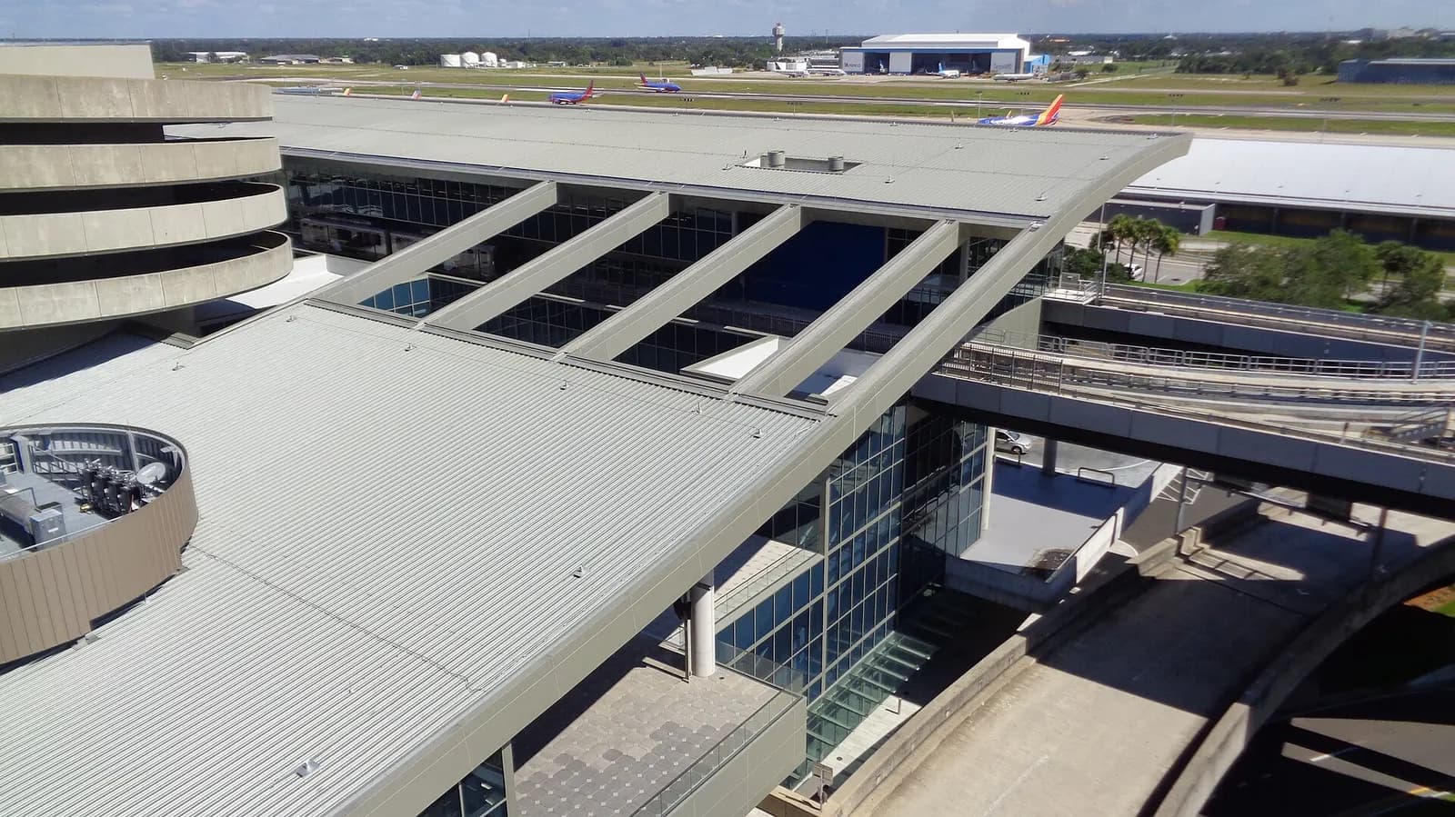 Exterior of the SkyConnect station attached to Tampa International Airport's main terminal, with glass walls and modern architecture.