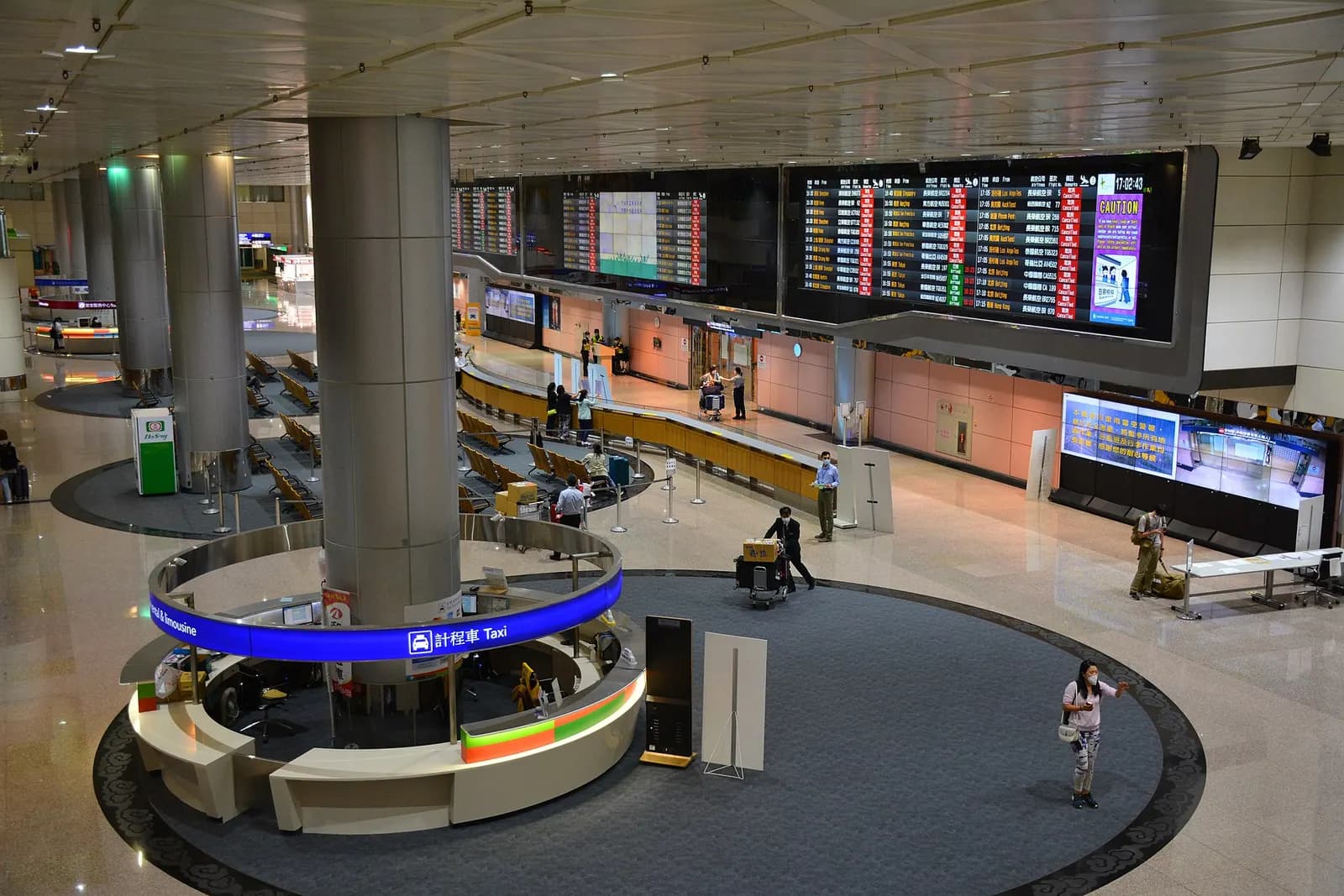 The bright, spacious arrivals hall of Terminal 2 with polished floors, signage, and a few travelers walking through after landing.