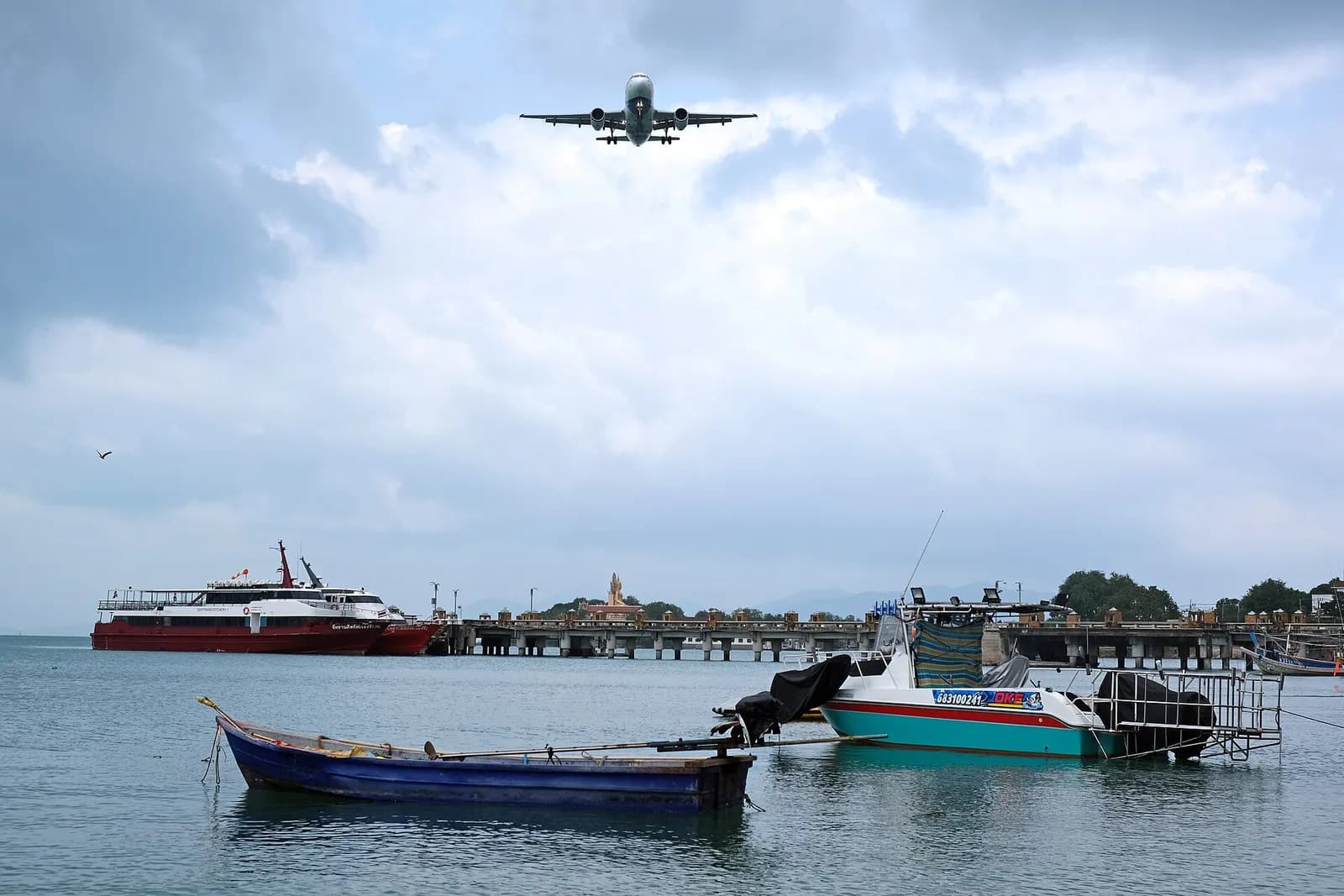 Bangkok Airways turboprop parked beside the open-air gate buildings at Ko Samui Airport