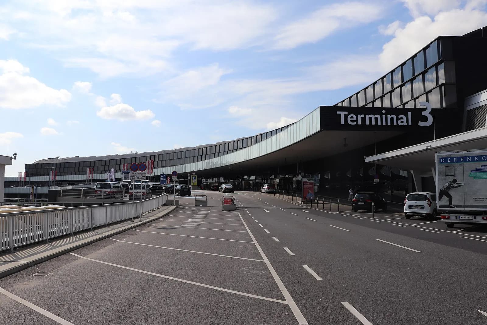 The modern Terminal 3 building at Vienna International Airport, with large glass facades and angular architecture, seen from outside on a clear day.