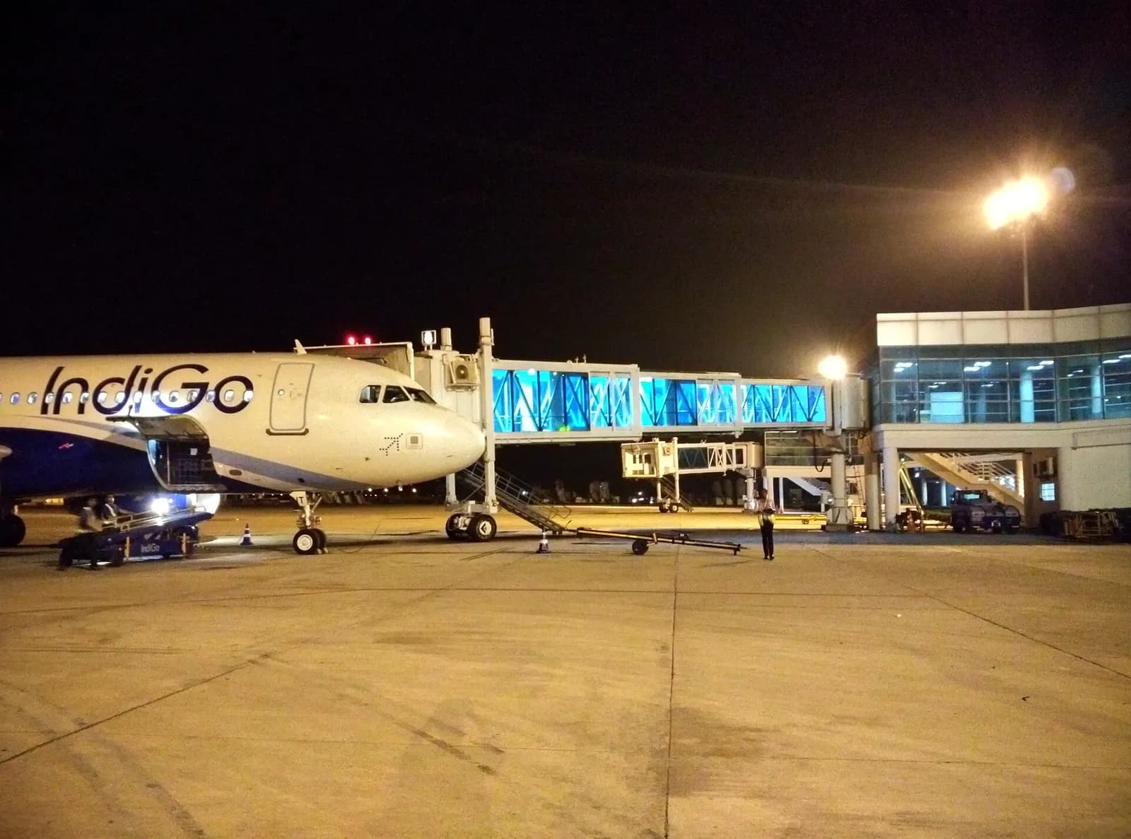 An IndiGo aircraft being serviced by an aerobridge at Varanasi Airport