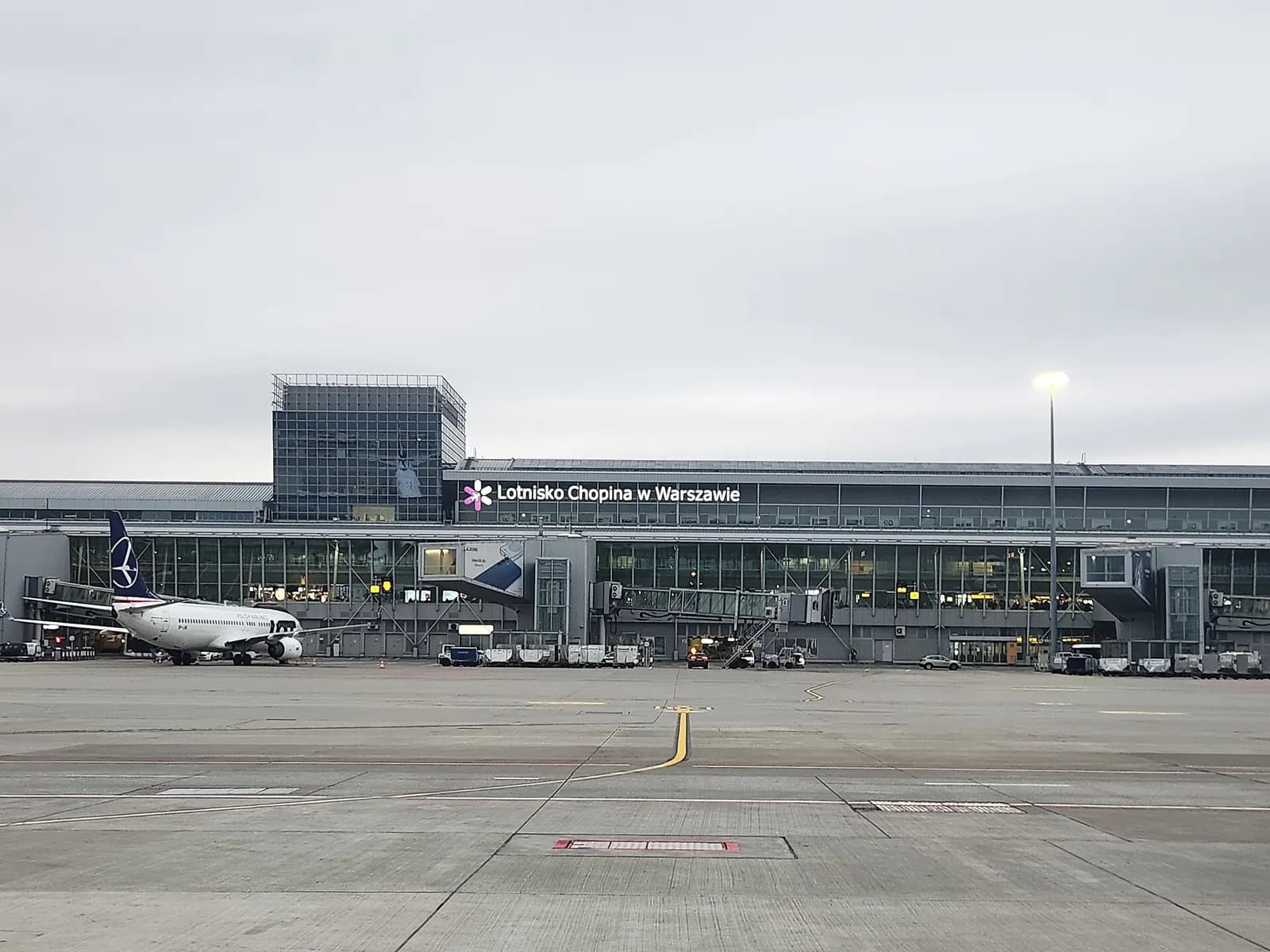 A contemporary view inside or overlooking Warsaw Chopin Airport in winter, showing the terminal spaces and passenger areas in December.