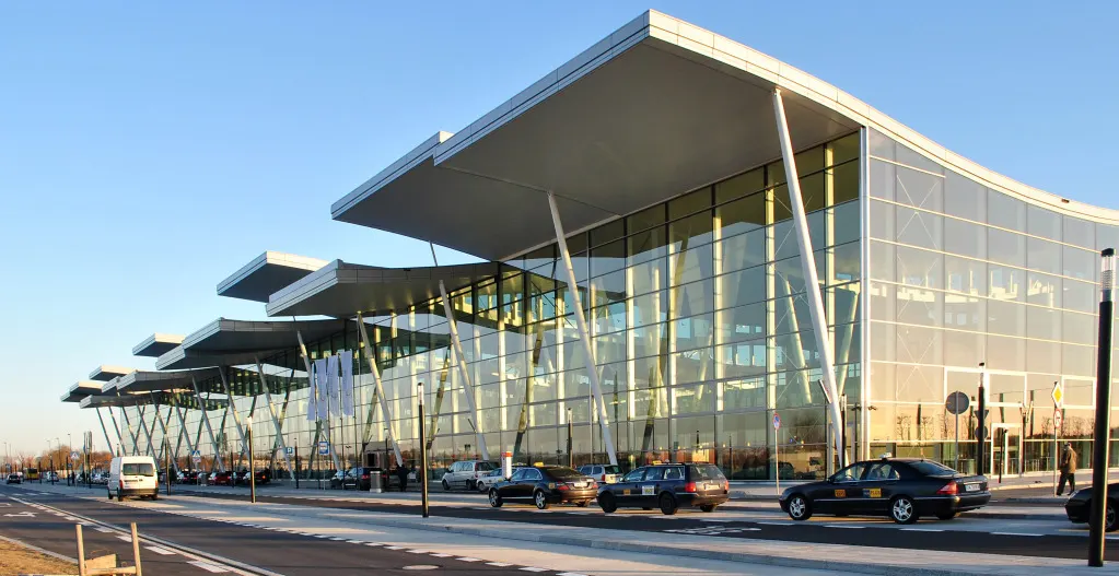Cropped view of Wrocław Airport Terminal T2 entrance canopy and glass front.