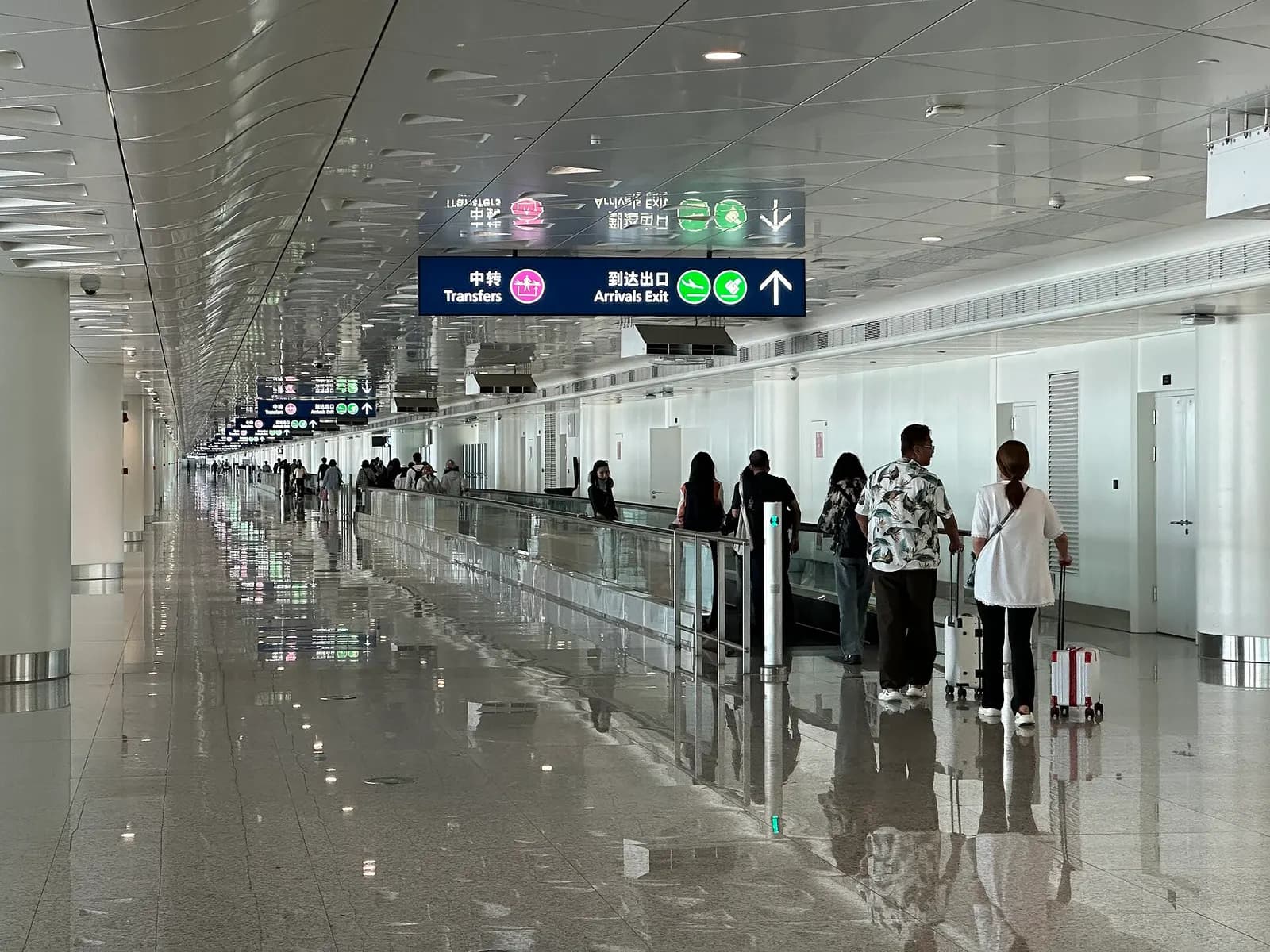 The international arrivals corridor in Terminal 3, with signage, tiled flooring, and immigration processing areas for arriving passengers.