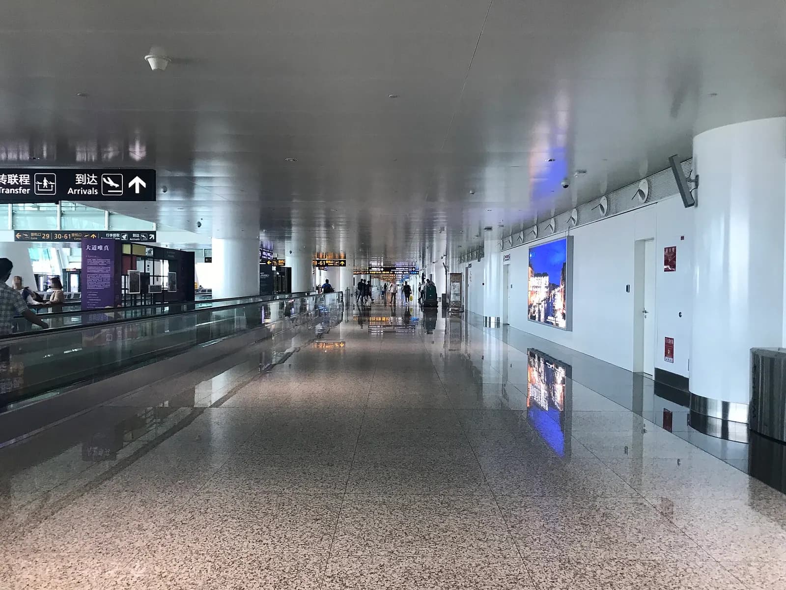 A wide, brightly lit Terminal 3 concourse with high ceilings, check-in counters, and travelers moving through the departures hall.