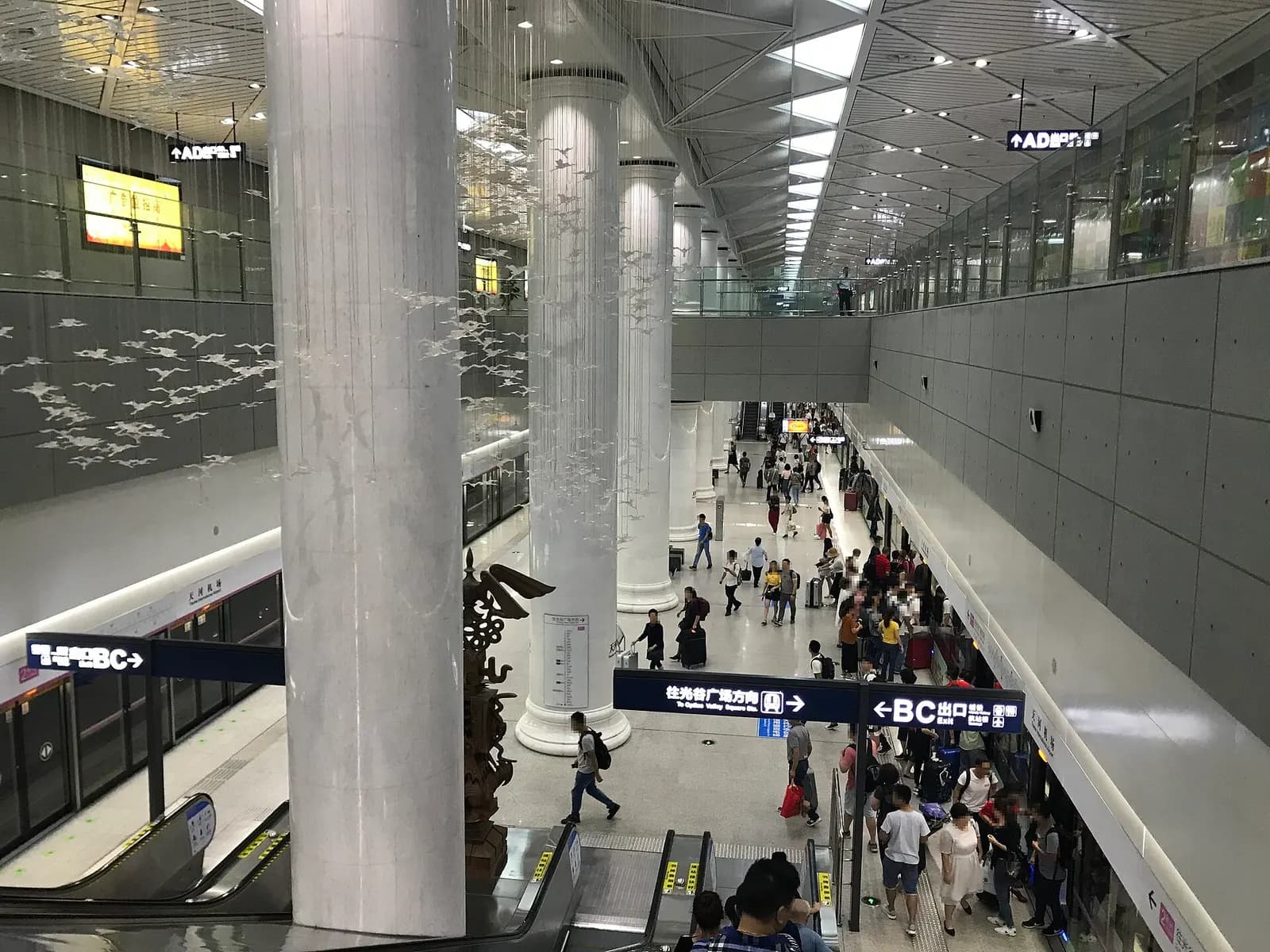 The platform at Tianhe International Airport Station on Wuhan Metro Line 2, with a train stopped at the platform and station signage overhead.