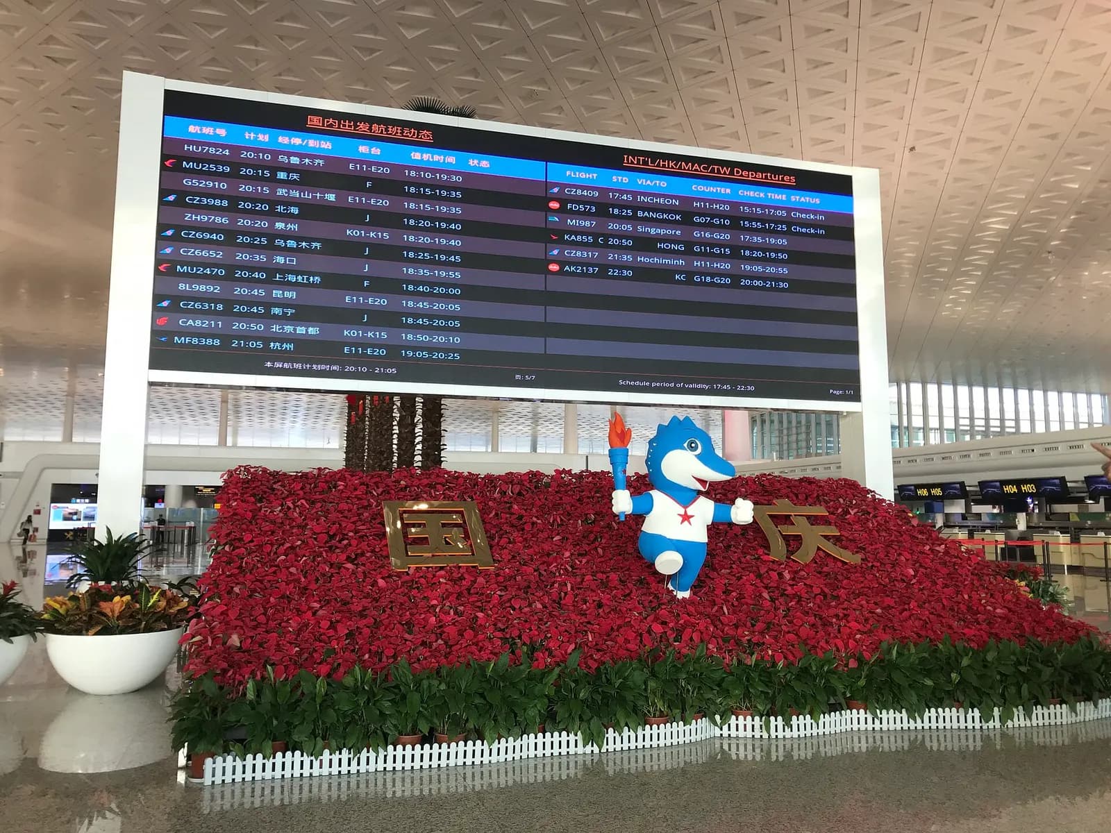 A large electronic flight information board listing departure times, destinations, and gate numbers above the Terminal 3 concourse.