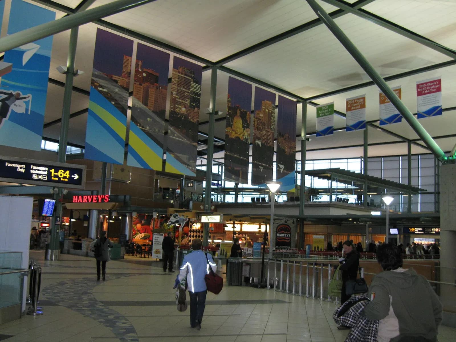 Central hall of Edmonton International Airport with Gates 1–64 wayfinding and Harvey's