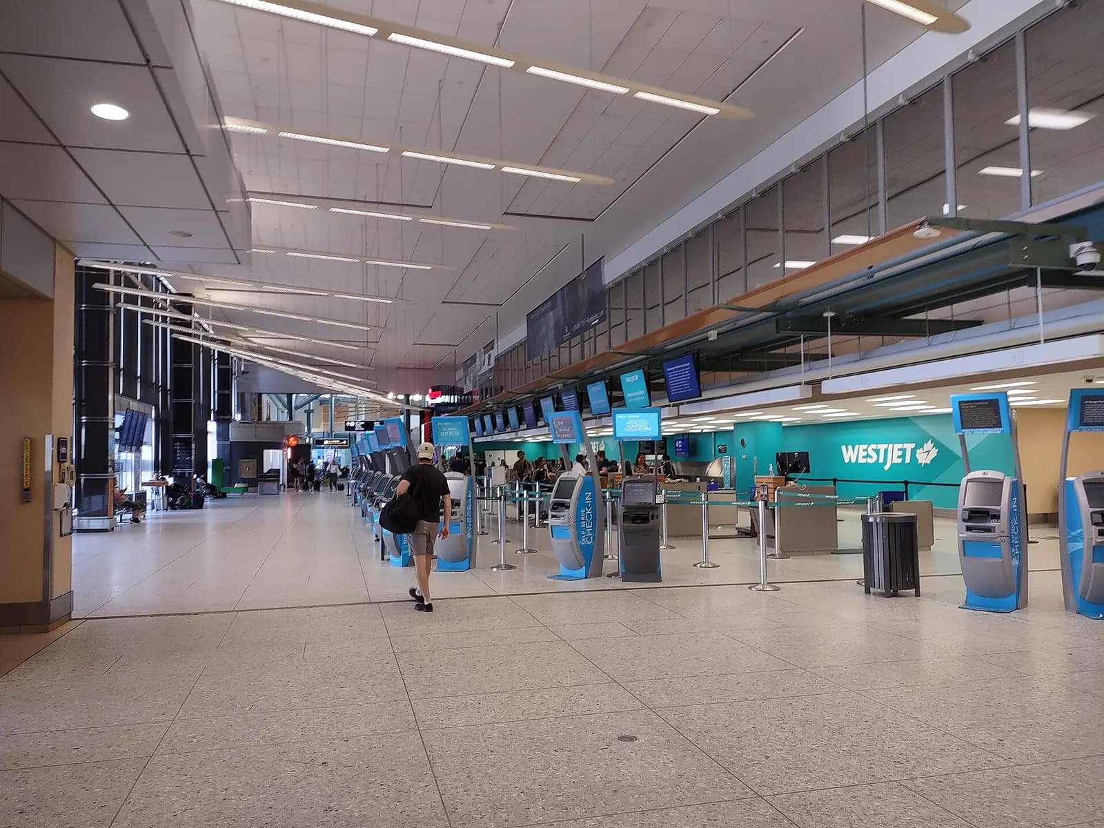 WestJet self-serve kiosks and check-in counters in the Edmonton International Airport departures hall, June 2023