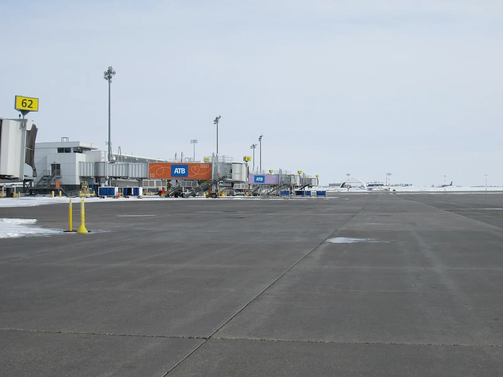 Snowy apron and jet bridges at Edmonton International Airport, including Gate 62 with ATB-branded bridges