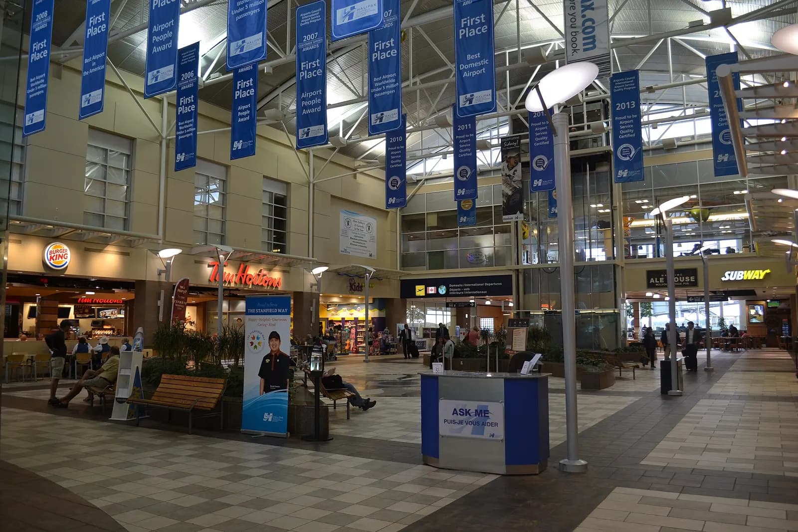 Landside Airport Square with Tim Hortons, award banners, and a Stanfield Way information desk.