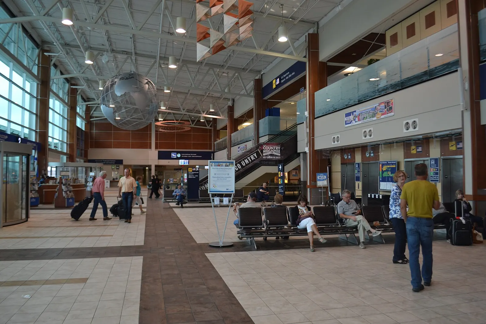 Landside hall looking toward the bilingual U.S. Departures / International Arrivals signs on the upper level.