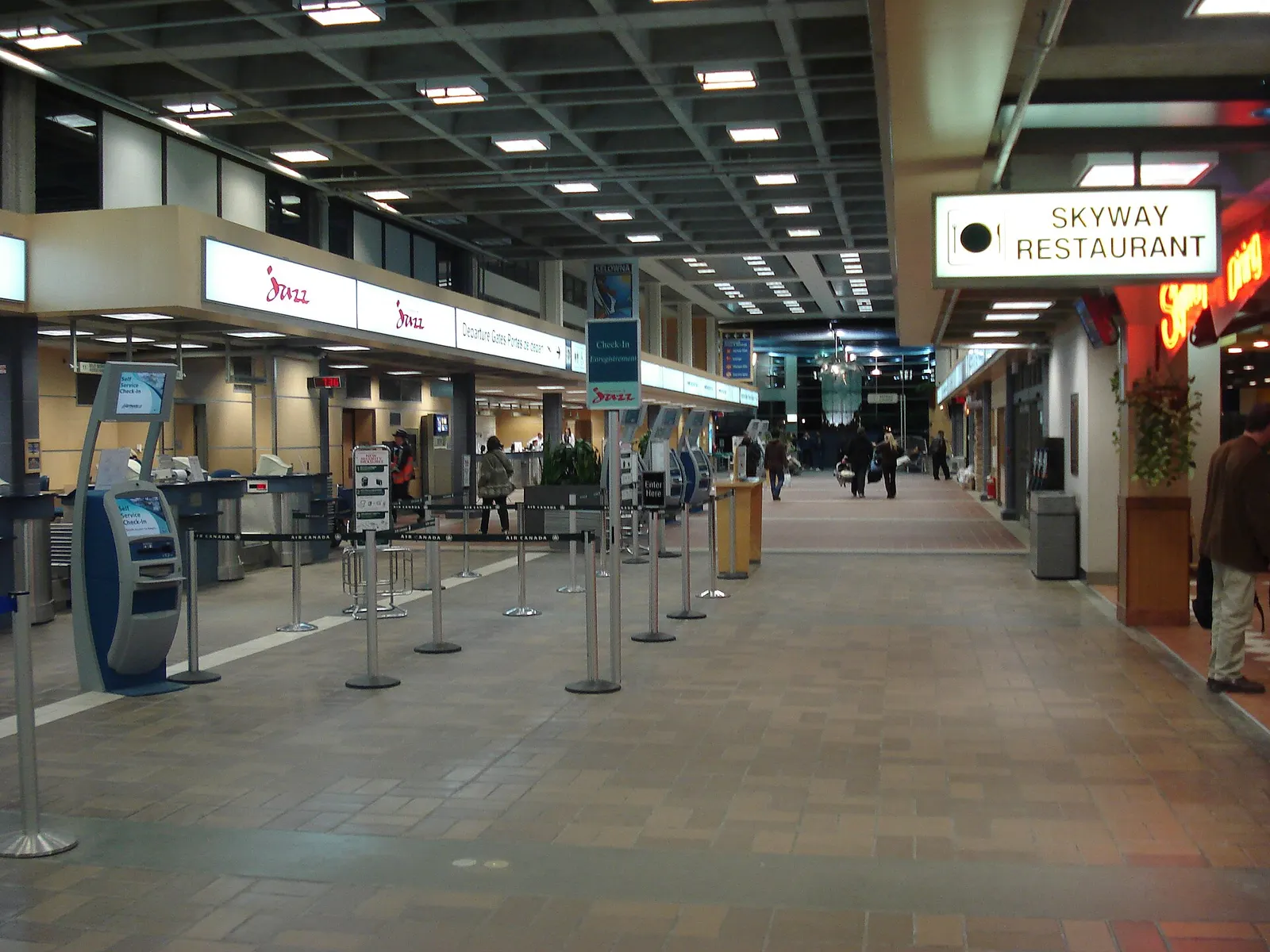 Historic 2007 landside exterior of the Kelowna International Airport terminal with the curved glass facade and curb.