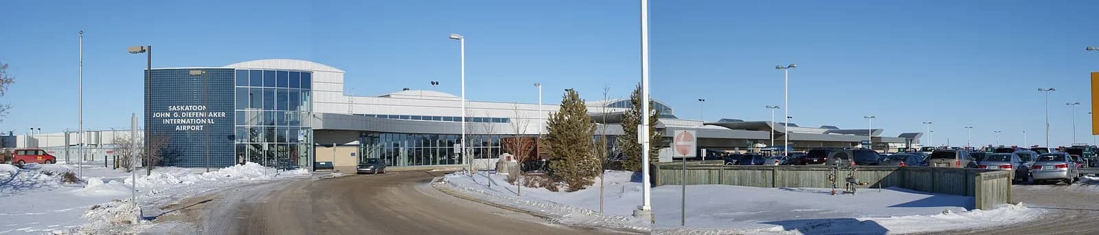 Wide winter exterior of the Saskatoon John G. Diefenbaker International Airport terminal building at dusk, photographed in 2009 before the 2015 expansion.