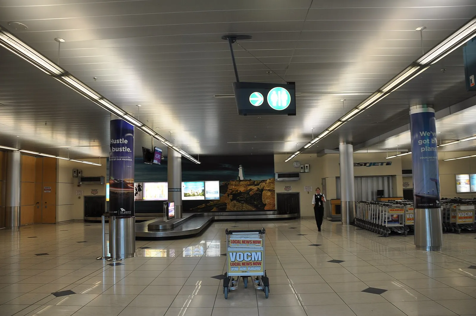 Arrivals baggage carousel at St. John's International Airport with the Newfoundland and Labrador exit in view, June 2015.