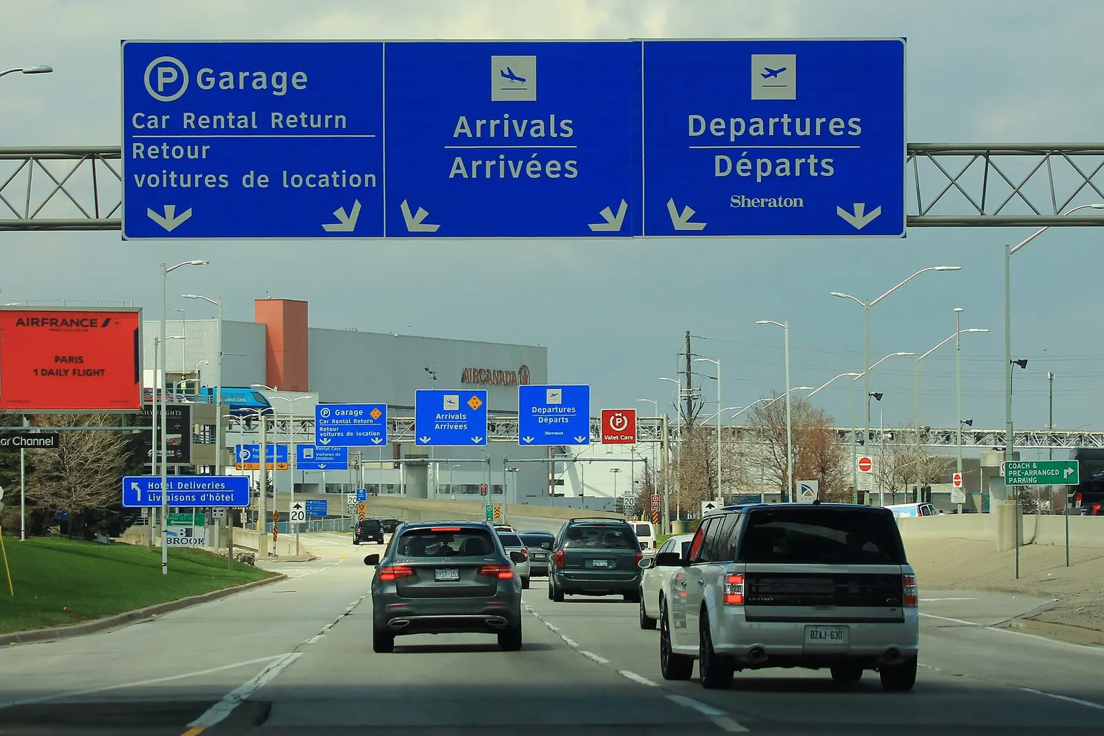 The multi-level Terminal 1 parking garage and covered pedestrian walkways connect directly to the arrivals and departures curb areas.