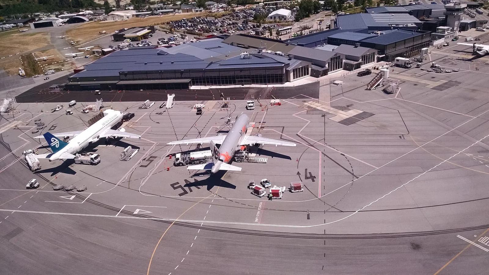 View of planes at Queenstown Airport from Over the Top Helicopter ZK-IDN