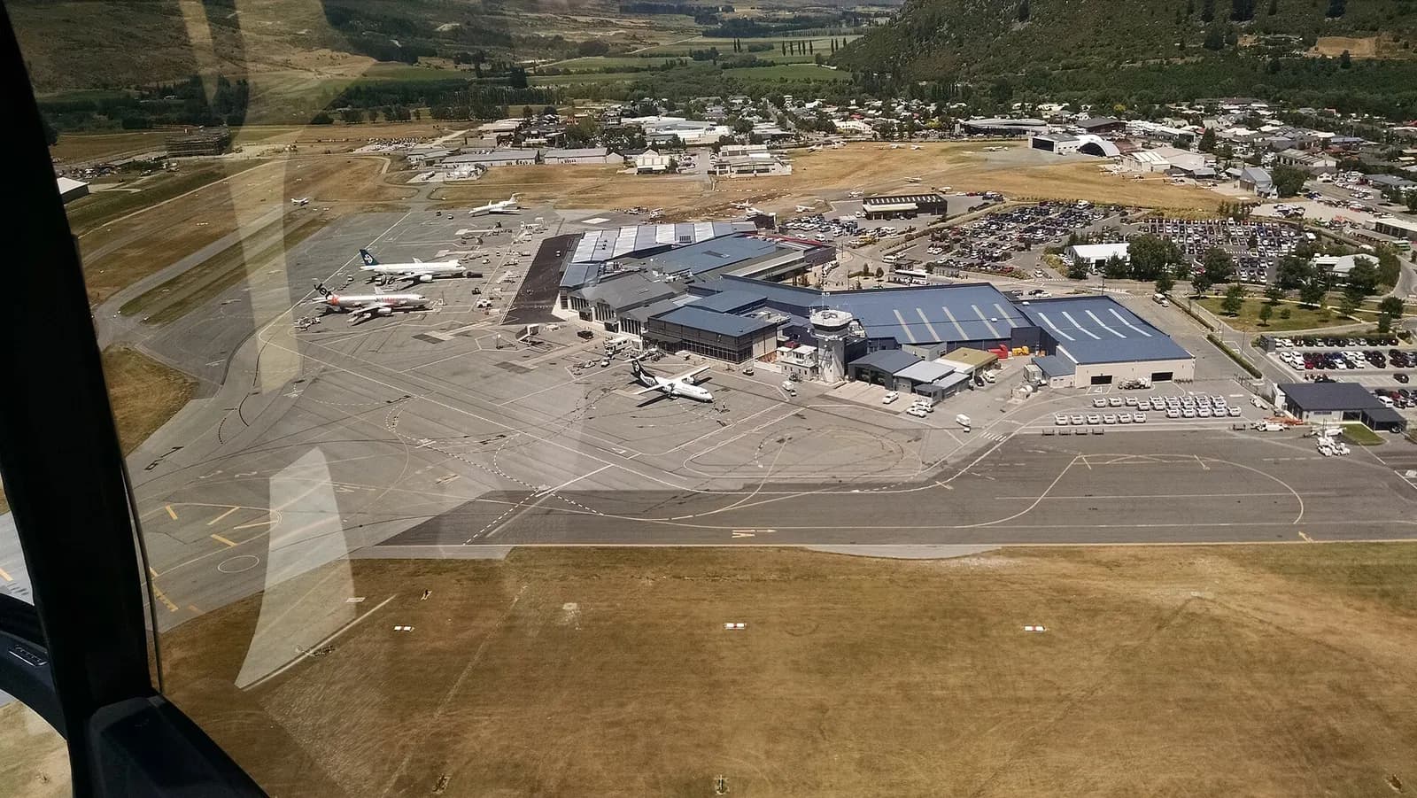 View of planes at Queenstown Airport from Over the Top Helicopter ZK-IDN
